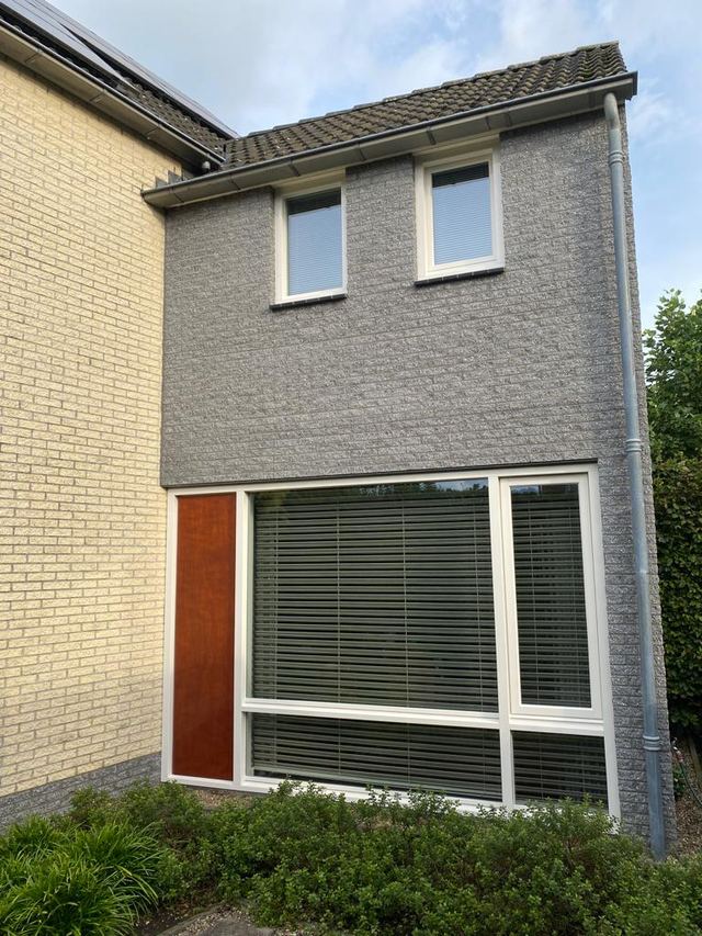 Grijs geschilderde gevel met witte kozijnen