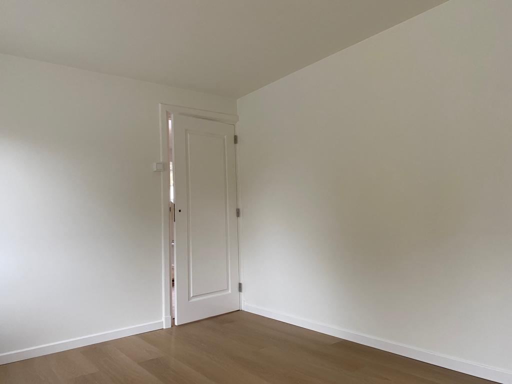 Wit geschilderde binnendeur en muren in een lichte kamer